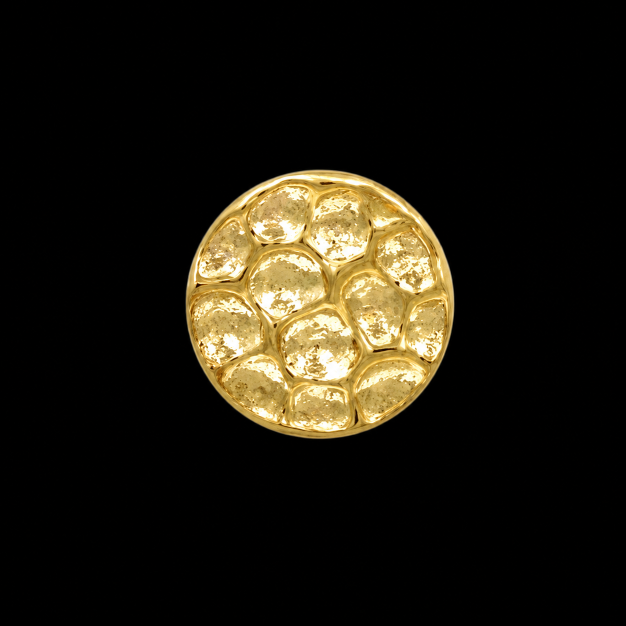 A gold disc covered in hand-struck dimples that catch the light unevenly, on black.