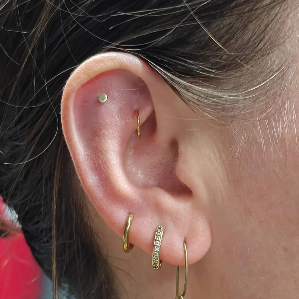 Curated ear with helix and flat piercings, healed